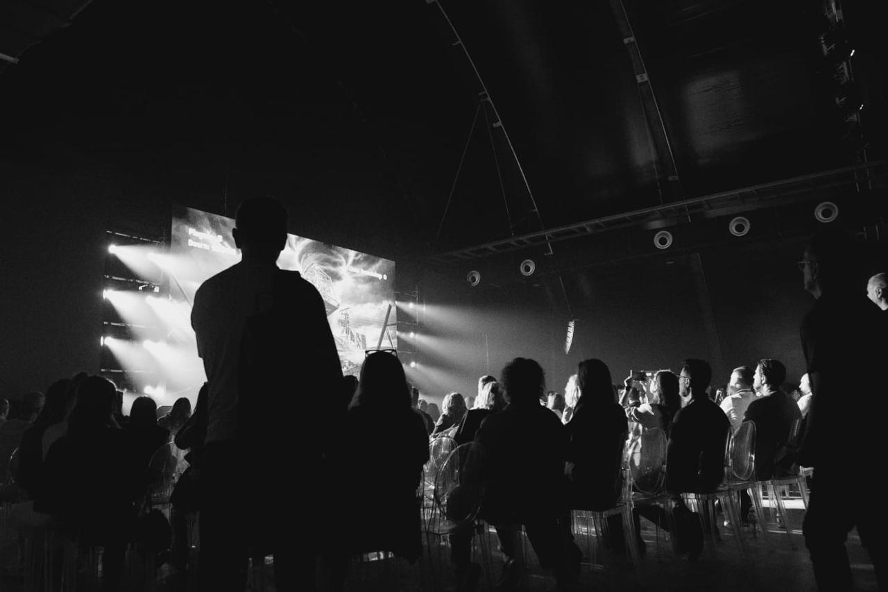 Audience facing a brightly lit stage