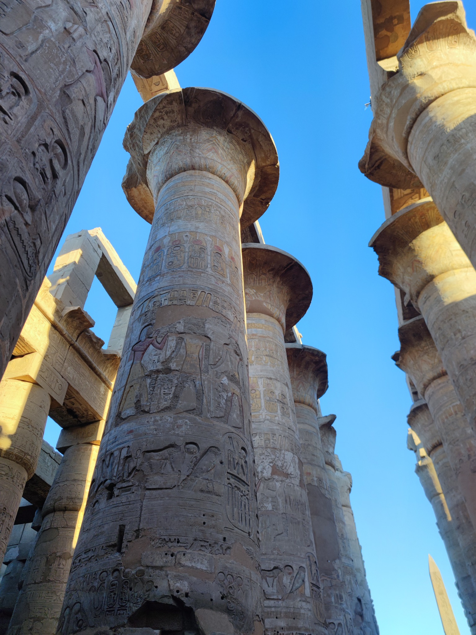 Ancient Egyptian temple columns against a clear blue sky